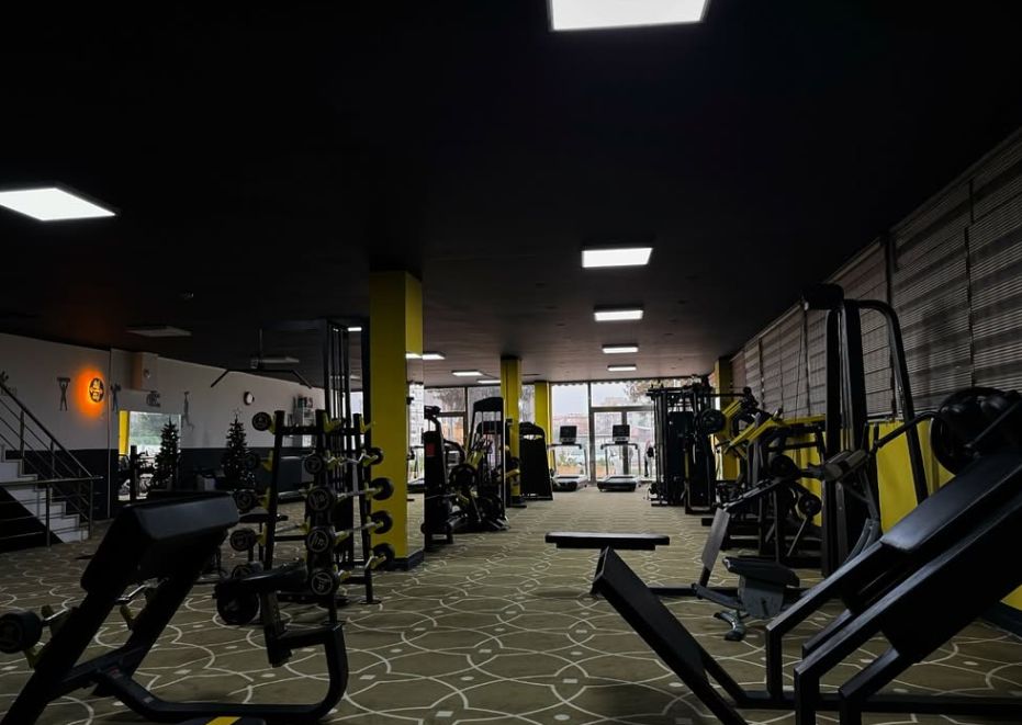 Salonun derinliği: sarı sütunlar, bench ve makineler
